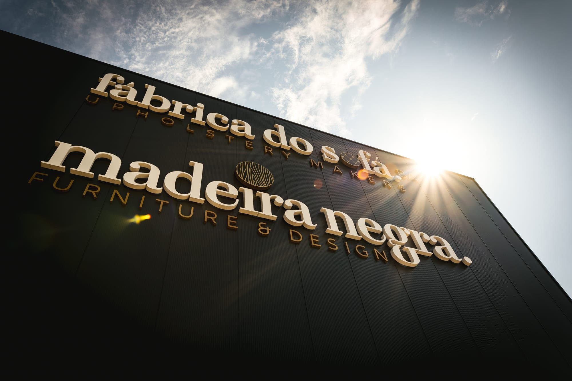 Fábrica do Sofá and Madeira Negra lettering on the factory facade in Paços de Ferreira